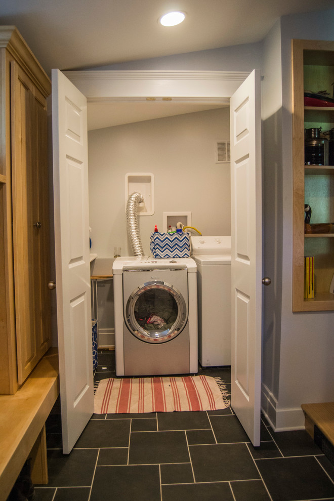 Foto di una lavanderia multiuso classica di medie dimensioni con ante con riquadro incassato, ante in legno chiaro, pareti grigie e lavatrice e asciugatrice affiancate