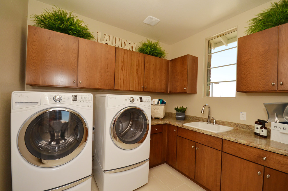 Inspiration for a medium sized classic l-shaped utility room in Phoenix with a built-in sink, flat-panel cabinets, medium wood cabinets, laminate countertops, beige walls, porcelain flooring and a side by side washer and dryer.