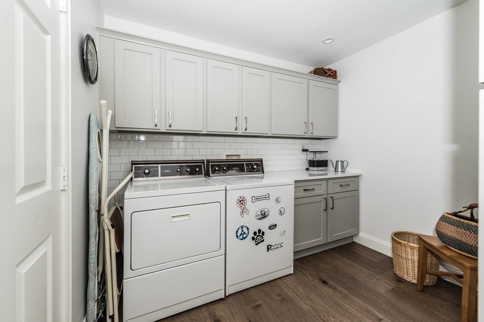 Mid-sized trendy single-wall medium tone wood floor and brown floor dedicated laundry room photo in Dallas with beaded inset cabinets, gray cabinets, quartzite countertops, white walls, a side-by-side washer/dryer and white countertops