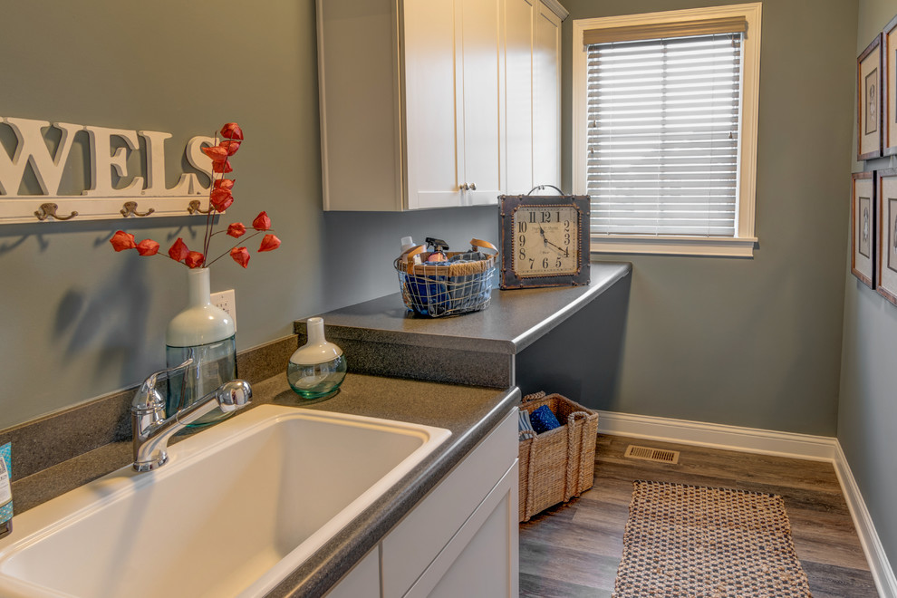 Arts and crafts single-wall dark wood floor utility room photo in Indianapolis with shaker cabinets, a drop-in sink, white cabinets, laminate countertops, gray walls and a side-by-side washer/dryer