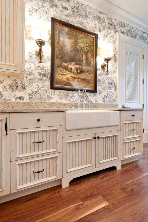 Example of a large classic l-shaped dark wood floor utility room design in Atlanta with a farmhouse sink, beige cabinets, granite countertops and a side-by-side washer/dryer