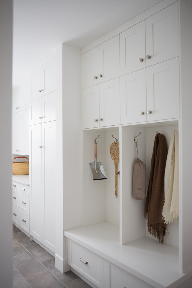 Bild på en mellanstor lantlig l-formad tvättstuga, med skåp i shakerstil, vita skåp och vita väggar
