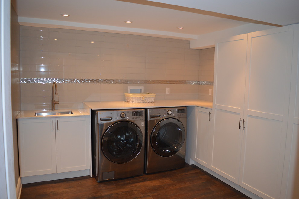 This is an example of a medium sized contemporary l-shaped separated utility room in Montreal with a submerged sink, shaker cabinets, white cabinets, quartz worktops, grey walls, lino flooring and a side by side washer and dryer.