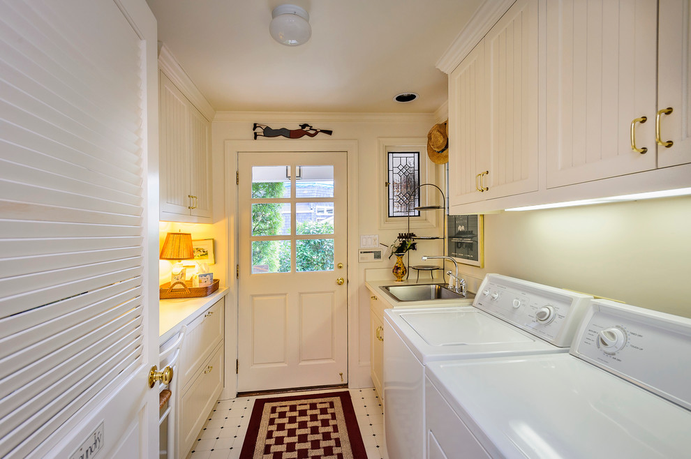 Zweizeilige, Mittelgroße Rustikale Waschküche mit Einbauwaschbecken, Schrankfronten im Shaker-Stil, weißen Schränken, Quarzwerkstein-Arbeitsplatte, weißer Wandfarbe, Linoleum und Waschmaschine und Trockner nebeneinander in San Francisco