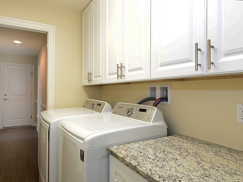 Medium sized traditional single-wall separated utility room in Miami with raised-panel cabinets, white cabinets, granite worktops, beige walls, dark hardwood flooring and a side by side washer and dryer.