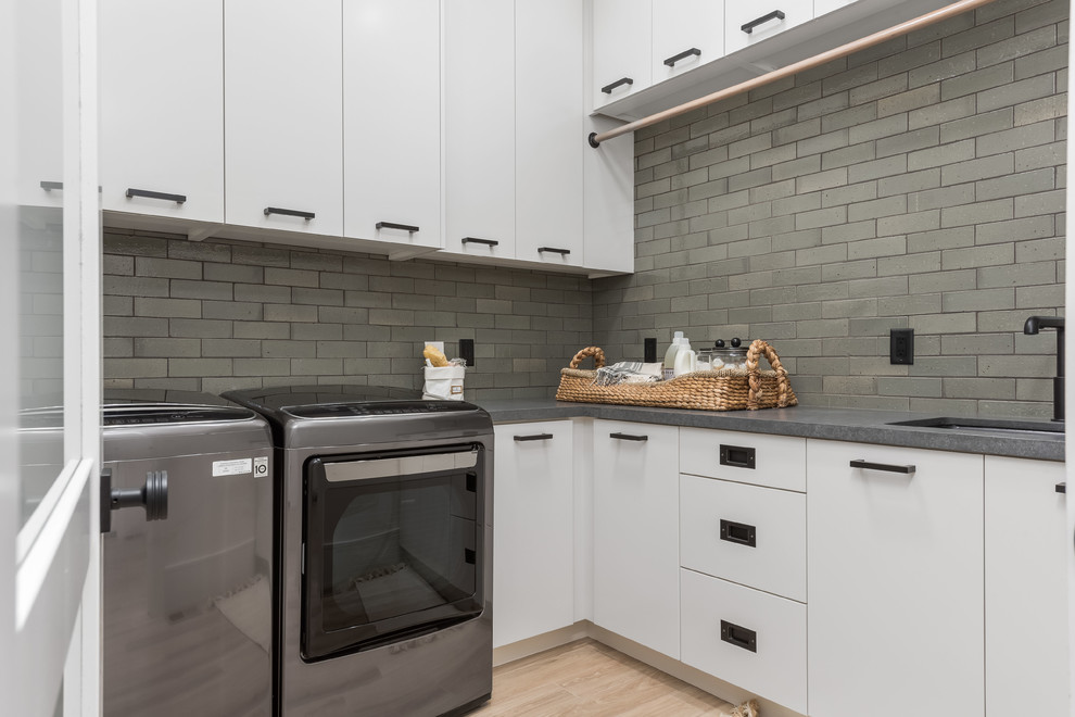 Inspiration for a large contemporary l-shaped separated utility room in Salt Lake City with a built-in sink, flat-panel cabinets, white cabinets, grey walls, porcelain flooring, a side by side washer and dryer, beige floors and grey worktops.