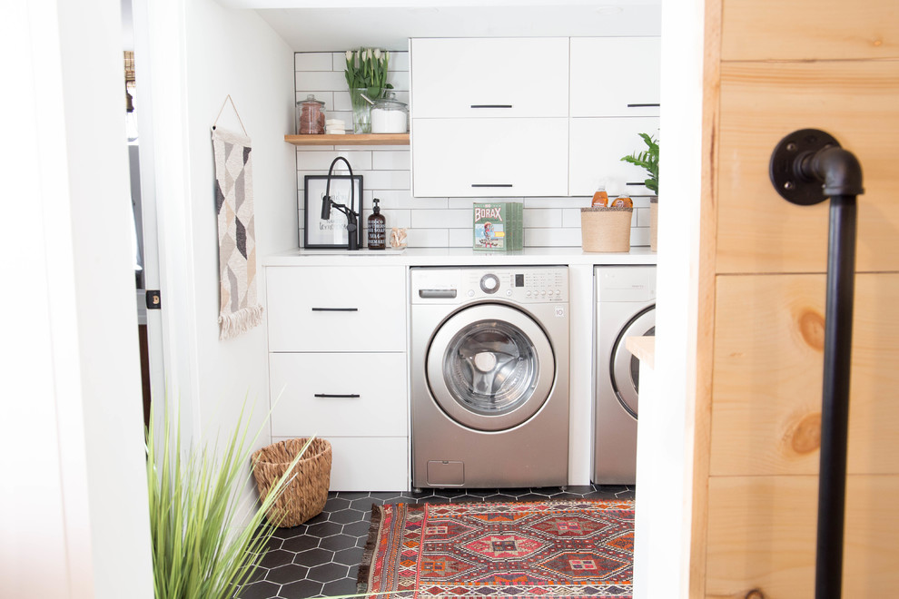 Inspiration pour une petite buanderie minimaliste dédiée avec un évier encastré, un placard à porte plane, des portes de placard blanches, un plan de travail en quartz modifié, un mur blanc, un sol en carrelage de céramique, des machines côte à côte et un sol noir.