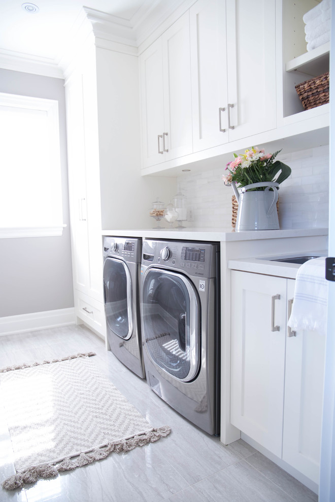Einzeilige, Mittelgroße Klassische Waschküche mit Unterbauwaschbecken, Schrankfronten im Shaker-Stil, weißen Schränken, Quarzwerkstein-Arbeitsplatte, weißer Wandfarbe, braunem Holzboden, Waschmaschine und Trockner nebeneinander und braunem Boden in Toronto