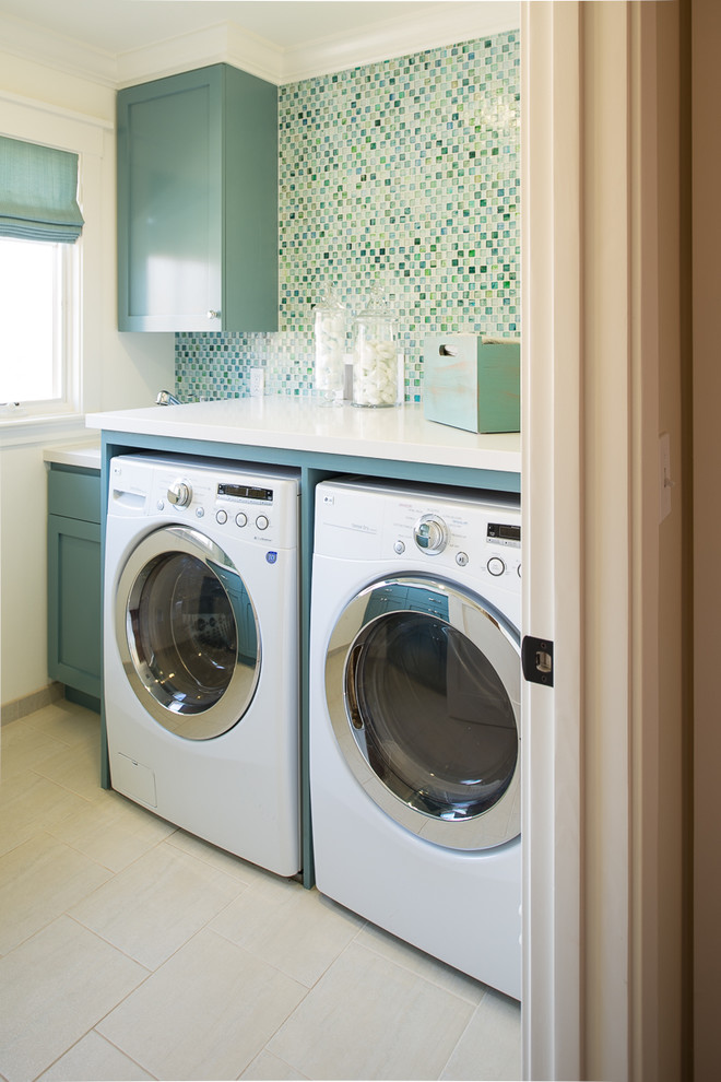 Diseño de lavadero clásico con armarios estilo shaker, puertas de armario azules, paredes blancas, lavadora y secadora juntas, suelo beige y encimeras blancas