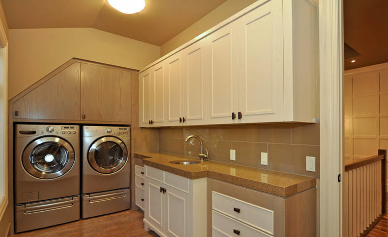 Example of a mid-sized trendy l-shaped ceramic tile dedicated laundry room design in Calgary with an undermount sink, raised-panel cabinets, beige cabinets, granite countertops, beige walls and a side-by-side washer/dryer