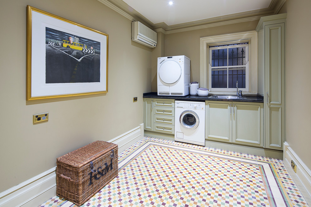 Photo of a victorian single-wall separated utility room in Gold Coast - Tweed with a single-bowl sink, beige cabinets, onyx worktops, beige walls, ceramic flooring, a stacked washer and dryer and recessed-panel cabinets.