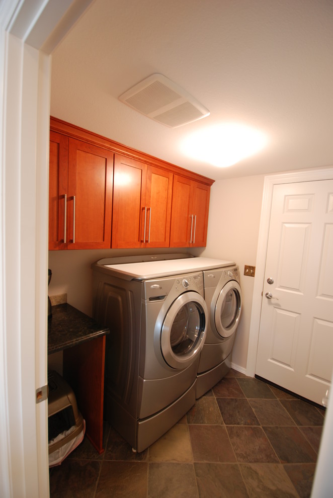 シアトルにある低価格の小さなトラディショナルスタイルのおしゃれな洗濯室 (I型、レイズドパネル扉のキャビネット、中間色木目調キャビネット、御影石カウンター、ベージュの壁、スレートの床、左右配置の洗濯機・乾燥機) の写真