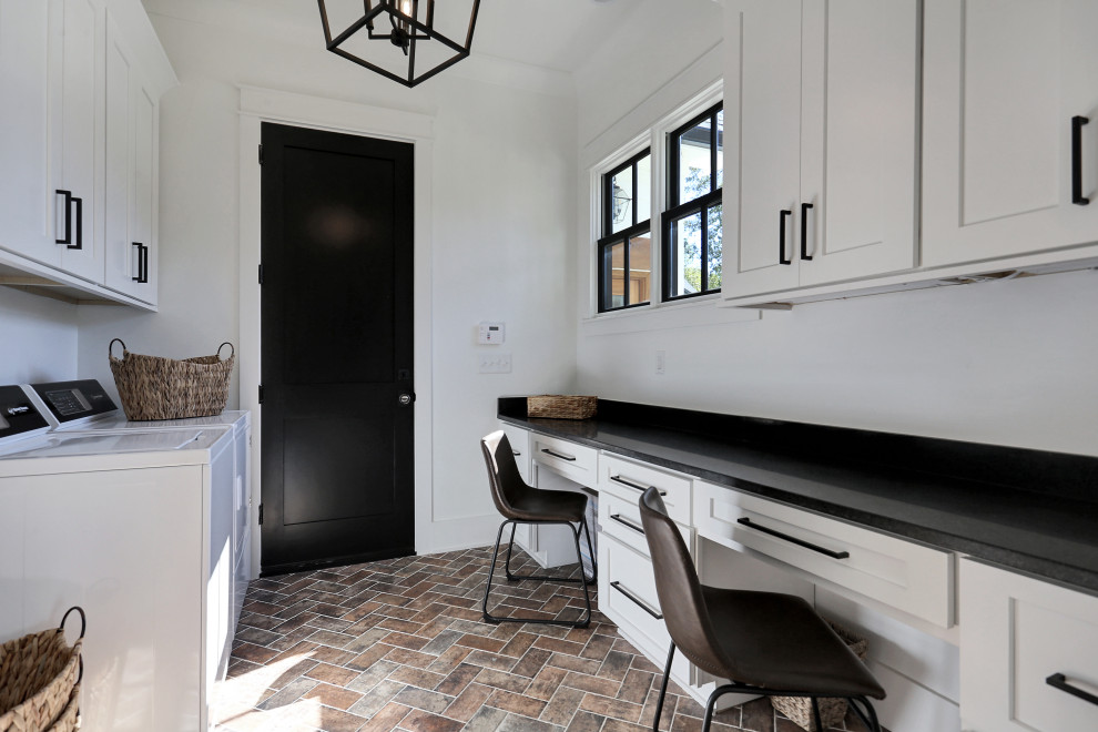 Idéer för ett stort klassiskt svart parallellt grovkök, med luckor med infälld panel, vita skåp, granitbänkskiva, vita väggar, tegelgolv, en tvättmaskin och torktumlare bredvid varandra och flerfärgat golv