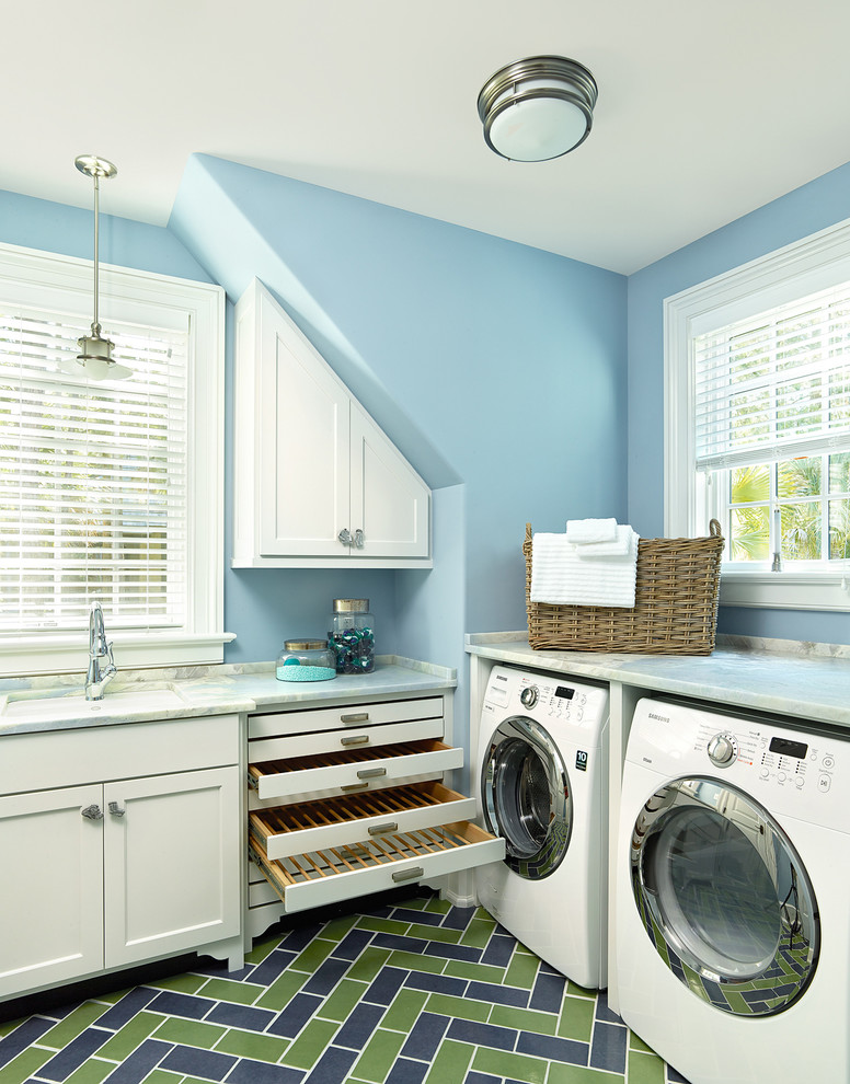 チャールストンにある中くらいなトランジショナルスタイルのおしゃれな洗濯室 (L型、アンダーカウンターシンク、シェーカースタイル扉のキャビネット、白いキャビネット、青い壁、左右配置の洗濯機・乾燥機、マルチカラーの床) の写真
