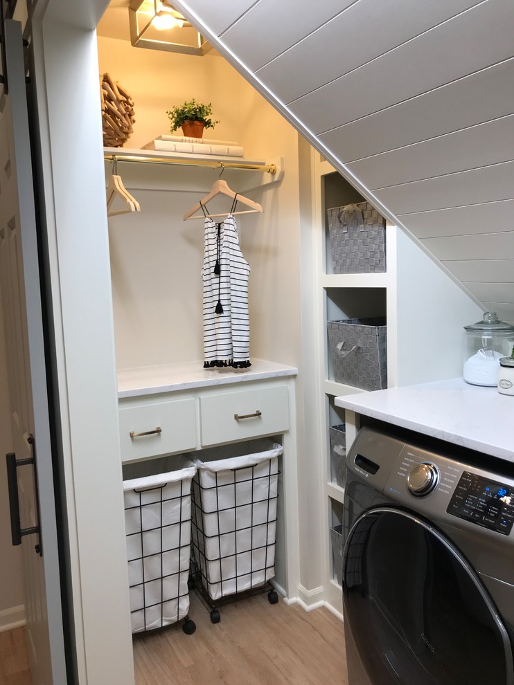 Inspiration for a small eclectic galley separated utility room in Kansas City with shaker cabinets, white cabinets, engineered stone countertops, beige walls, vinyl flooring, a side by side washer and dryer and brown floors.
