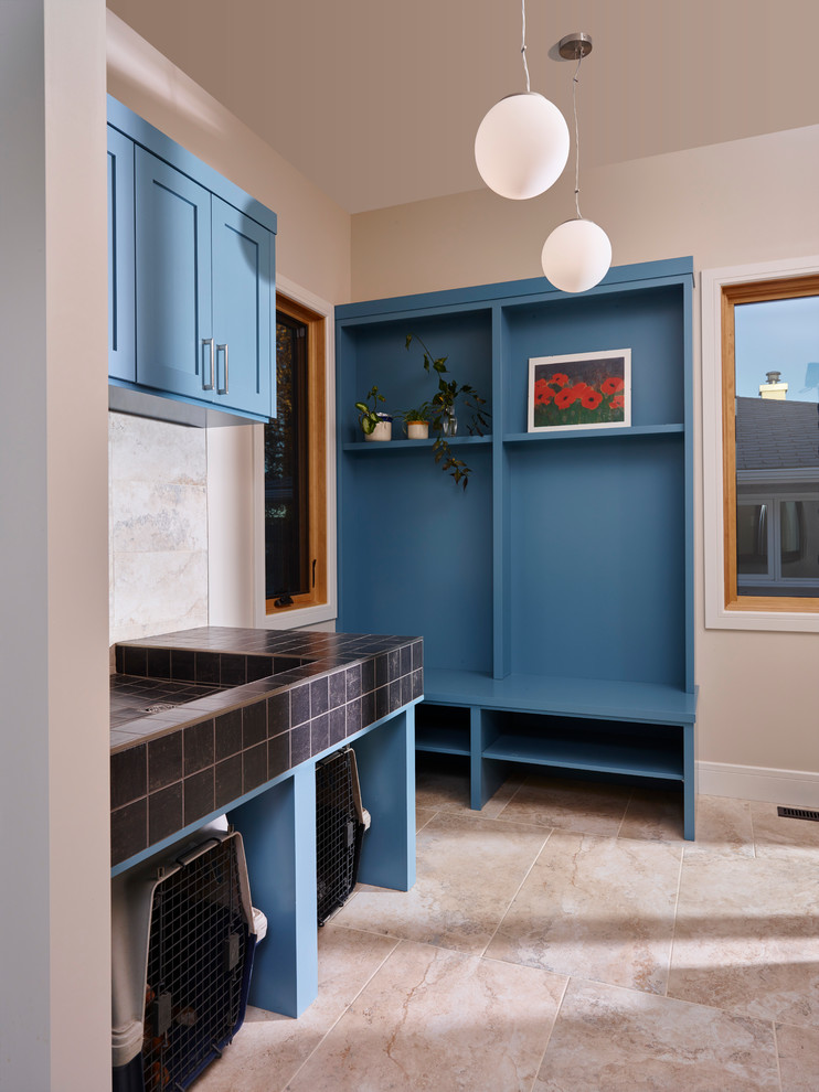 Multifunktionaler, Zweizeiliger, Großer Rustikaler Hauswirtschaftsraum mit Unterbauwaschbecken, Schrankfronten im Shaker-Stil, blauen Schränken, Granit-Arbeitsplatte, beiger Wandfarbe, Keramikboden und Waschmaschine und Trockner nebeneinander in Calgary