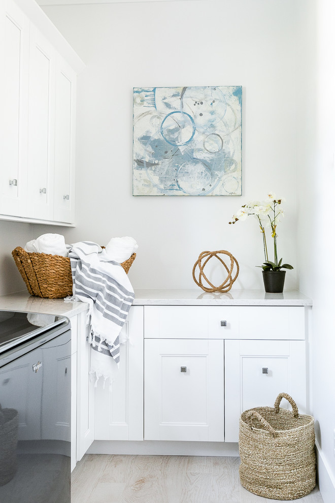 Esempio di una sala lavanderia stile marinaro con ante con riquadro incassato, ante bianche, pareti bianche, lavatrice e asciugatrice affiancate, pavimento beige e top grigio