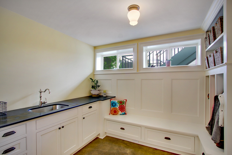 シアトルにある小さなトラディショナルスタイルのおしゃれな家事室 (ドロップインシンク、落し込みパネル扉のキャビネット、白いキャビネット、白い壁、無垢フローリング、左右配置の洗濯機・乾燥機) の写真