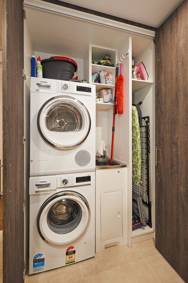 Foto di una lavanderia minimalista con ante marroni, pavimento in gres porcellanato e pavimento beige