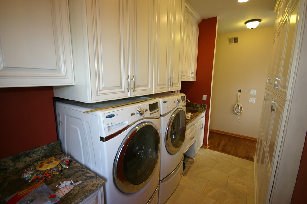 Exempel på ett litet modernt linjärt grovkök, med en undermonterad diskho, luckor med upphöjd panel, vita skåp, granitbänkskiva, beige stänkskydd, stänkskydd i stenkakel, klinkergolv i porslin, röda väggar och en tvättmaskin och torktumlare bredvid varandra