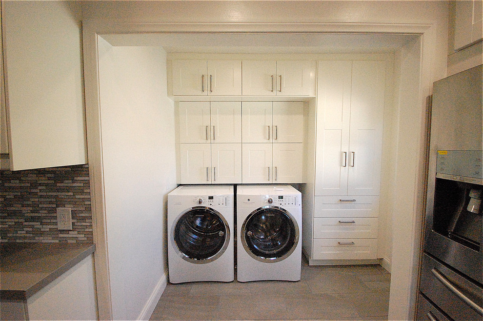 Ejemplo de lavadero multiusos y lineal tradicional de tamaño medio con armarios estilo shaker, puertas de armario blancas, paredes blancas, suelo de baldosas de porcelana y lavadora y secadora juntas
