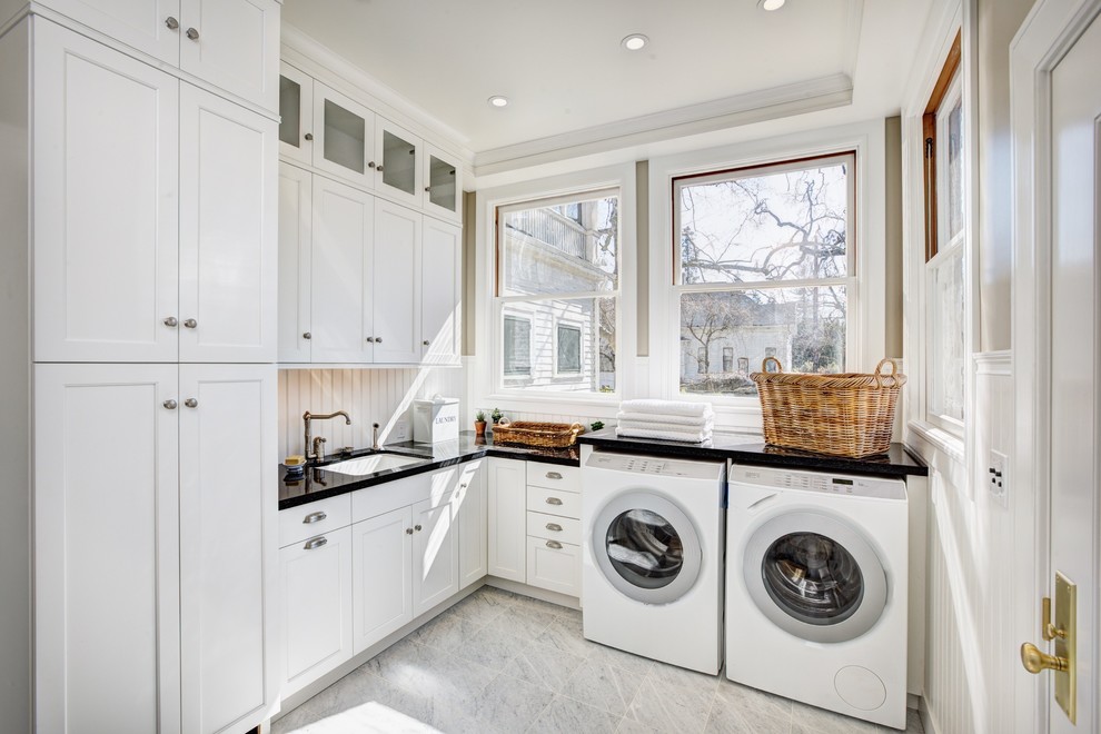 Trendy galley ceramic tile dedicated laundry room photo in Sacramento with recessed-panel cabinets, white cabinets, solid surface countertops, white walls, a side-by-side washer/dryer and an undermount sink