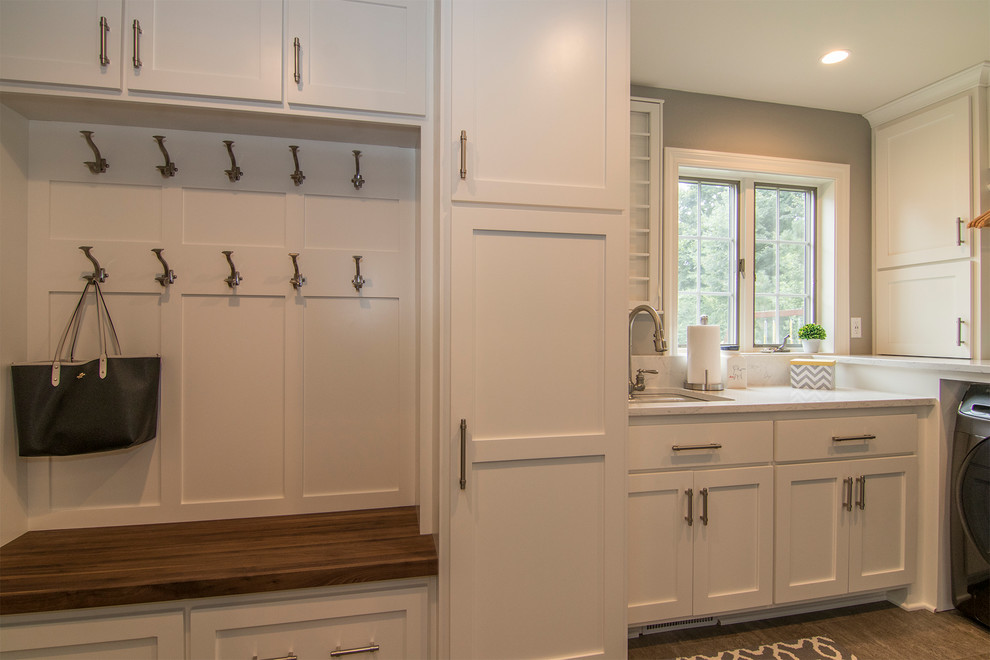 Example of a mid-sized transitional l-shaped vinyl floor and gray floor utility room design in Milwaukee with an undermount sink, shaker cabinets, white cabinets, quartzite countertops, gray walls, a side-by-side washer/dryer and gray countertops