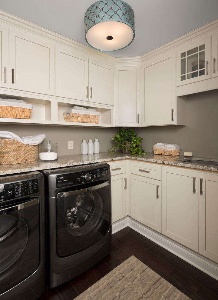Small transitional l-shaped dark wood floor and black floor dedicated laundry room photo in Other with white cabinets, gray walls, an undermount sink, shaker cabinets, quartz countertops, a side-by-side washer/dryer and beige countertops