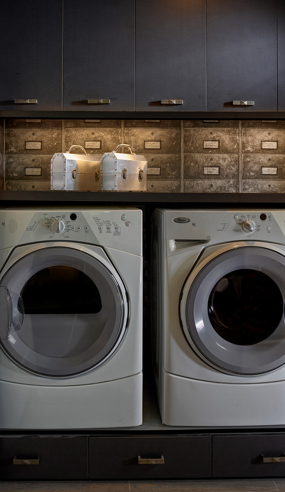 Exempel på en liten modern linjär tvättstuga enbart för tvätt, med släta luckor, svarta skåp, laminatbänkskiva, klinkergolv i porslin, en tvättmaskin och torktumlare bredvid varandra och bruna väggar