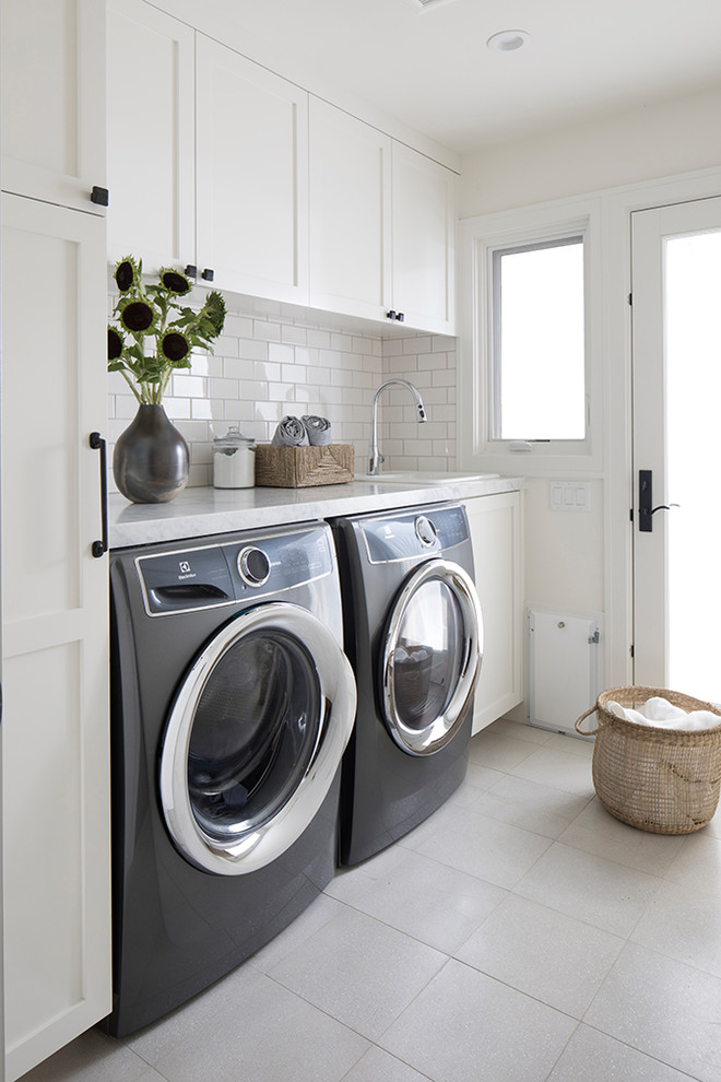 Inspiration for a small transitional single-wall ceramic tile and beige floor dedicated laundry room remodel in San Francisco with a drop-in sink, shaker cabinets, white cabinets, marble countertops, white walls, a side-by-side washer/dryer and white countertops