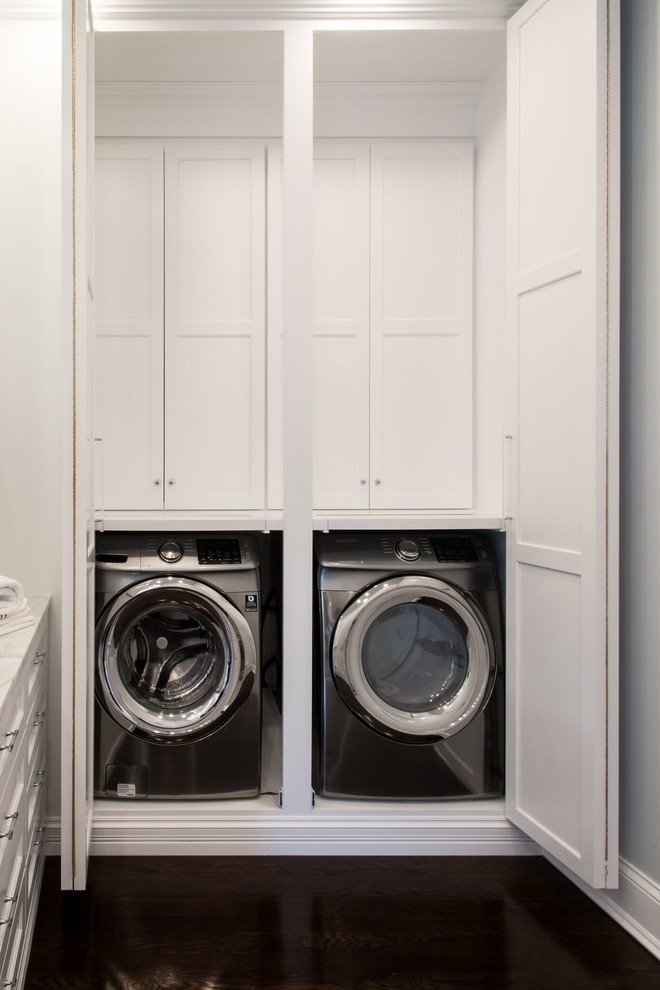 Exempel på en mellanstor klassisk l-formad tvättstuga, med vita skåp, bänkskiva i koppar, vita väggar, mörkt trägolv, en tvättmaskin och torktumlare bredvid varandra och skåp i shakerstil