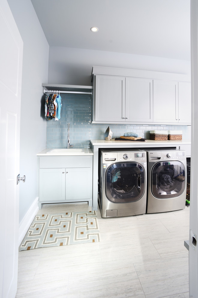 Bild på en stor vintage parallell tvättstuga enbart för tvätt, med skåp i shakerstil, vita skåp, grå väggar, klinkergolv i porslin, en tvättmaskin och torktumlare bredvid varandra och bänkskiva i kvarts