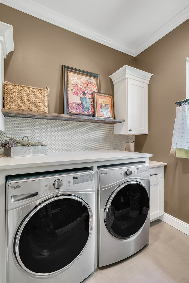 Bild på en mellanstor vintage linjär tvättstuga enbart för tvätt, med skåp i shakerstil, vita skåp, marmorbänkskiva, bruna väggar, travertin golv, en tvättmaskin och torktumlare bredvid varandra och beiget golv