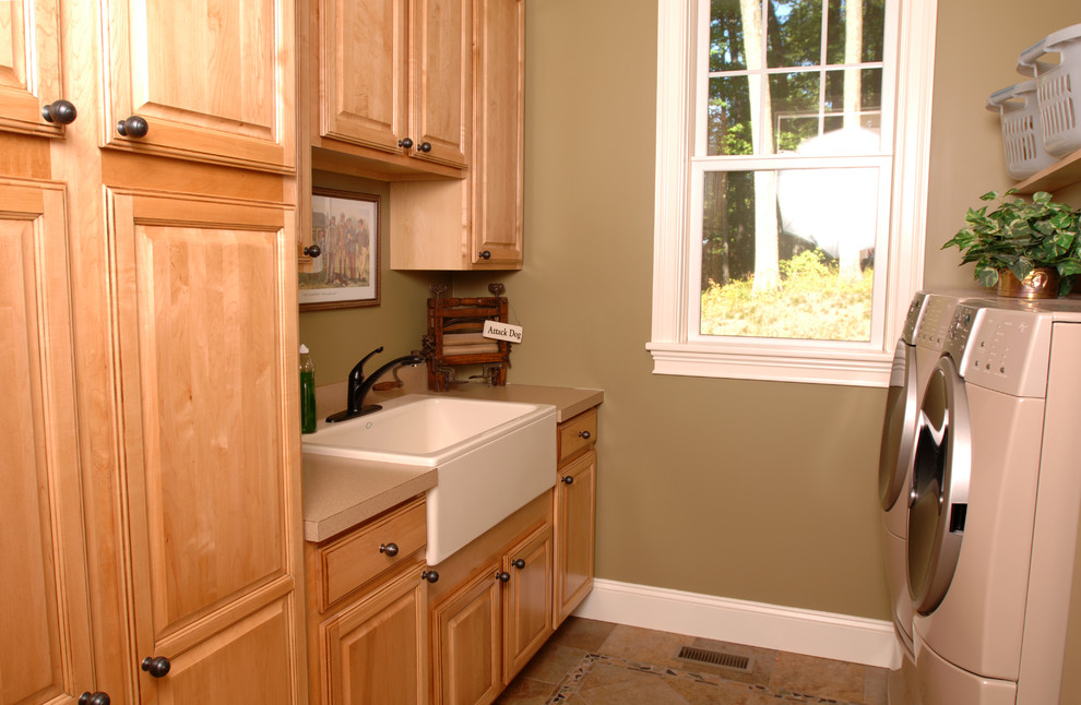 Inredning av en klassisk tvättstuga, med en rustik diskho, luckor med upphöjd panel, laminatbänkskiva, beige väggar, klinkergolv i keramik och en tvättmaskin och torktumlare bredvid varandra