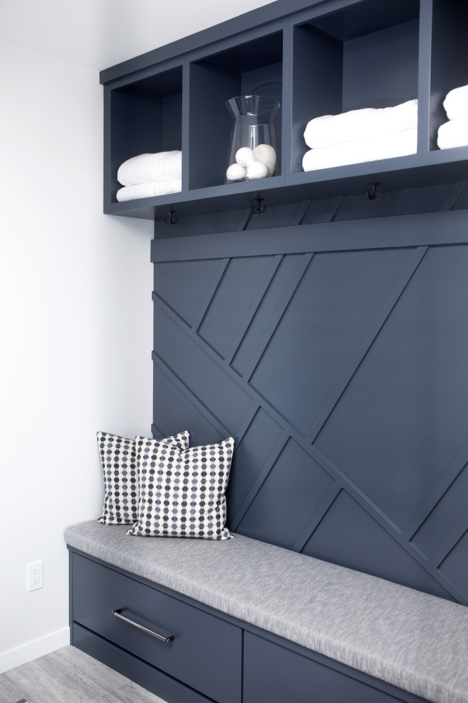 Esempio di una lavanderia multiuso design con ante lisce, ante blu, pareti multicolore, pavimento grigio e pannellatura