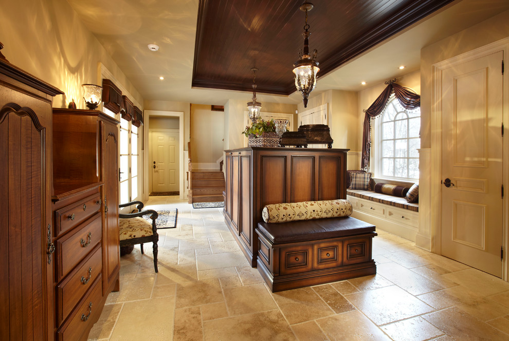 Modelo de cuarto de lavado clásico grande con armarios con paneles empotrados, paredes beige y puertas de armario de madera en tonos medios