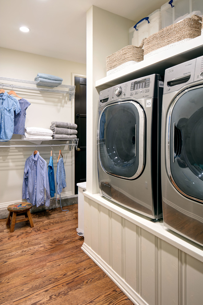 Idéer för att renovera en mellanstor medelhavsstil parallell tvättstuga enbart för tvätt, med vita väggar, mellanmörkt trägolv och en tvättmaskin och torktumlare bredvid varandra