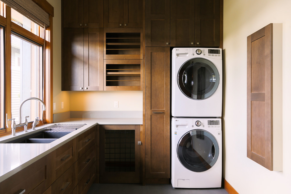 シアトルにある中くらいなラスティックスタイルのおしゃれな洗濯室 (L型、ダブルシンク、シェーカースタイル扉のキャビネット、白い壁、上下配置の洗濯機・乾燥機、濃色木目調キャビネット) の写真