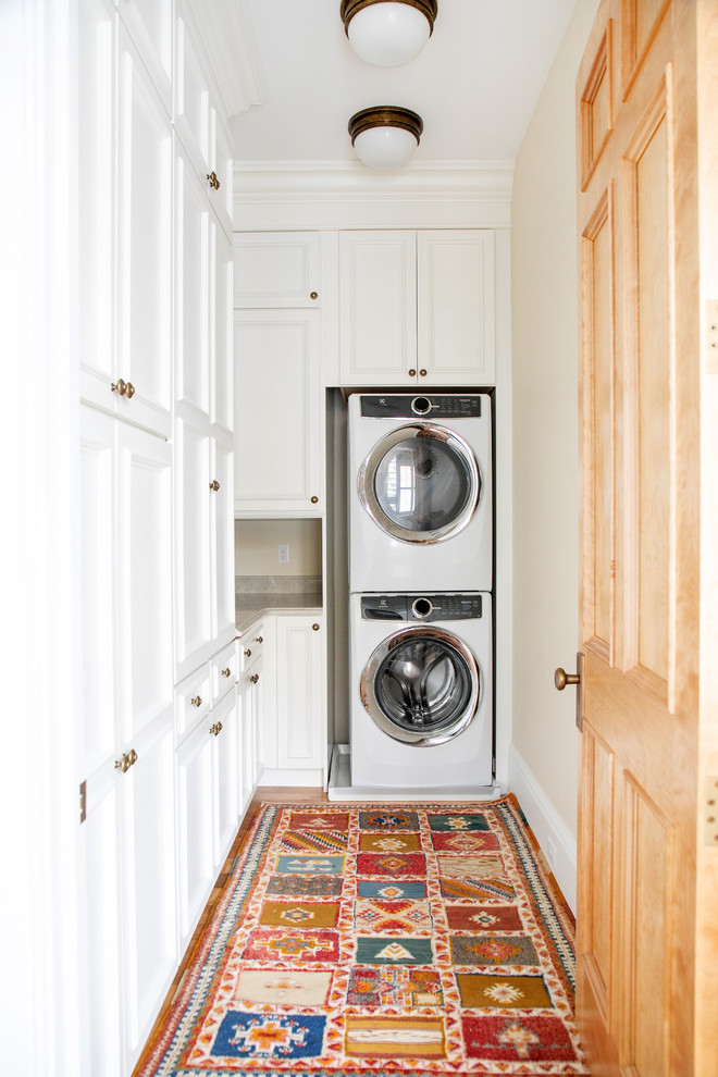 Idéer för mellanstora vintage l-formade tvättstugor enbart för tvätt, med en rustik diskho, luckor med infälld panel, vita skåp, vitt stänkskydd, stänkskydd i tunnelbanekakel, ljust trägolv, beige väggar, en tvättpelare och beiget golv