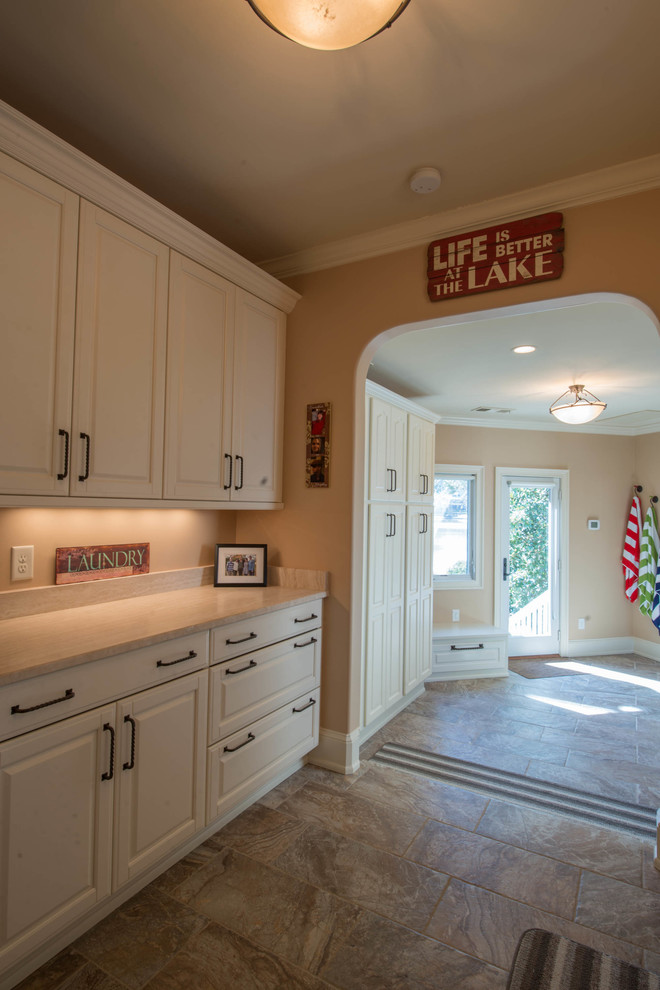 Medium sized classic galley utility room in Atlanta with white cabinets, a side by side washer and dryer, a submerged sink, raised-panel cabinets, limestone worktops, beige walls and porcelain flooring.
