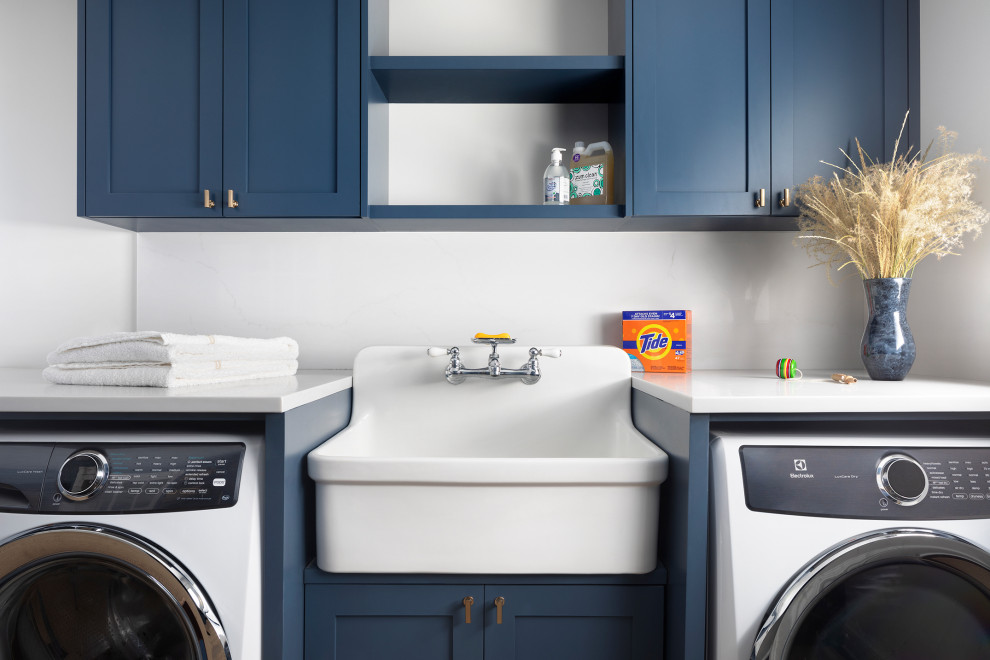 Medium sized rural separated utility room in New York with an utility sink, shaker cabinets, blue cabinets, engineered stone countertops, white walls, a side by side washer and dryer and white worktops.