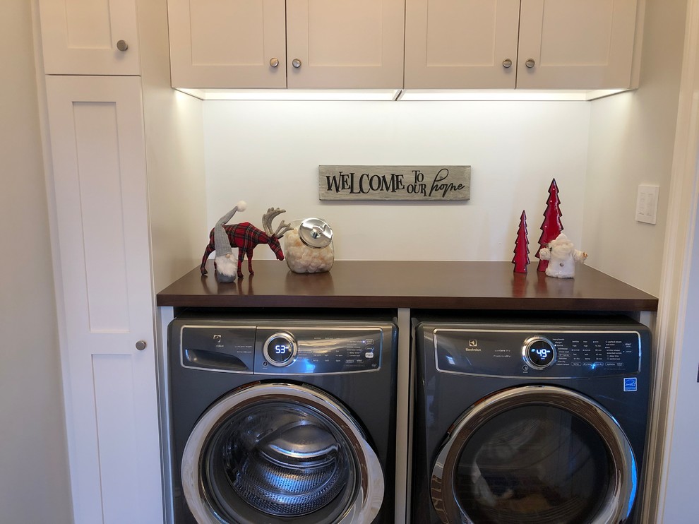 Example of a small trendy single-wall utility room design in Philadelphia with flat-panel cabinets, white cabinets and a side-by-side washer/dryer