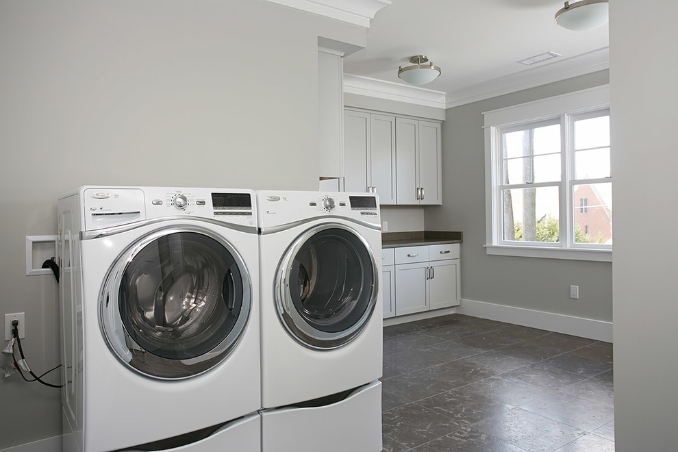 Idéer för stora amerikanska u-formade tvättstugor enbart för tvätt, med en undermonterad diskho, skåp i shakerstil, grå skåp, granitbänkskiva, grå väggar, klinkergolv i porslin och en tvättmaskin och torktumlare bredvid varandra