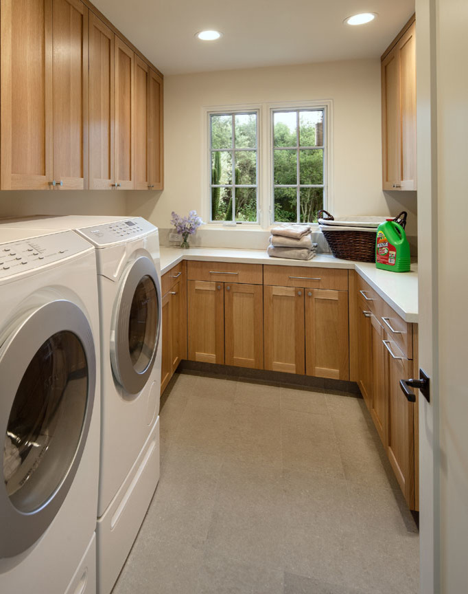 Exempel på en mellanstor klassisk tvättstuga enbart för tvätt, med skåp i shakerstil, vita väggar, en tvättmaskin och torktumlare bredvid varandra och skåp i mellenmörkt trä