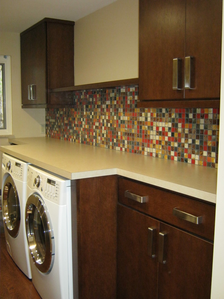 Trendy medium tone wood floor laundry room photo in Columbus with flat-panel cabinets, medium tone wood cabinets, beige walls, a side-by-side washer/dryer and a drop-in sink