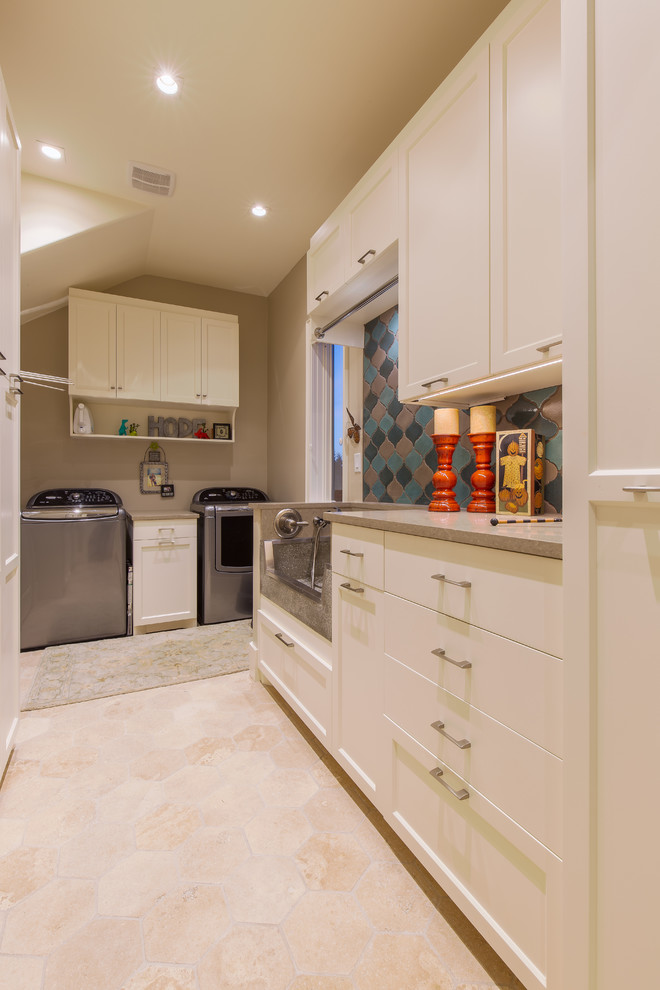 Design ideas for a large traditional u-shaped utility room in Austin with an utility sink, recessed-panel cabinets, white cabinets, engineered stone countertops, travertine flooring, a side by side washer and dryer and brown walls.