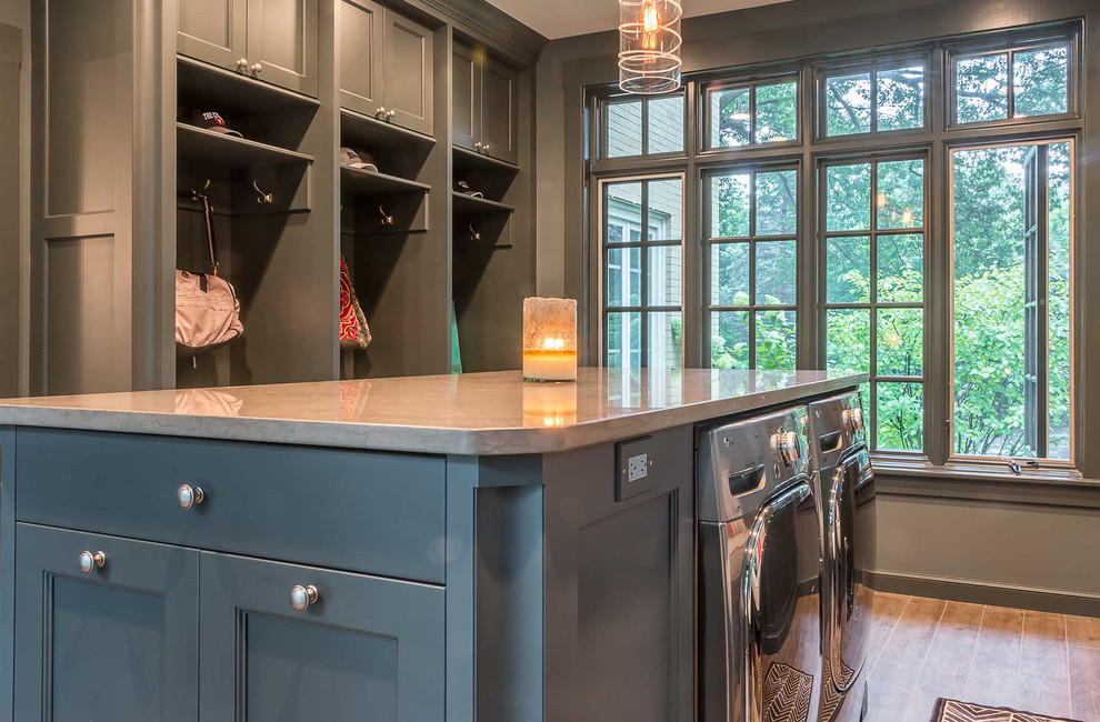 Large scandinavian utility room in Chicago with a submerged sink, flat-panel cabinets, grey cabinets, engineered stone countertops, grey walls, medium hardwood flooring and a side by side washer and dryer.