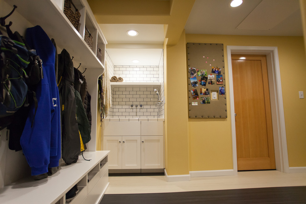 シアトルにあるお手頃価格の広いトランジショナルスタイルのおしゃれな家事室 (L型、一体型シンク、シェーカースタイル扉のキャビネット、白いキャビネット、ラミネートカウンター、黄色い壁、リノリウムの床、左右配置の洗濯機・乾燥機) の写真