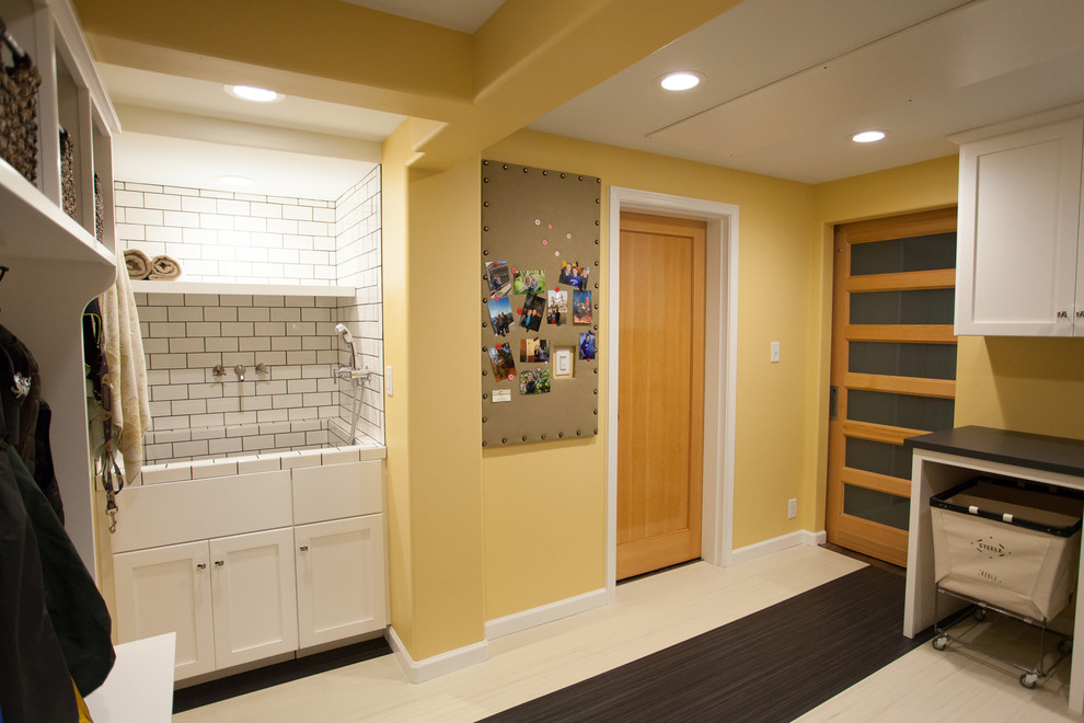 シアトルにあるお手頃価格の広いトランジショナルスタイルのおしゃれな家事室 (L型、シェーカースタイル扉のキャビネット、白いキャビネット、ラミネートカウンター、黄色い壁、リノリウムの床、スロップシンク) の写真
