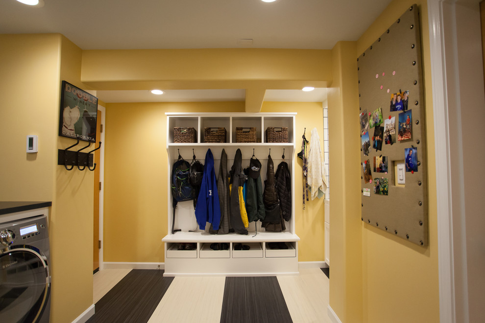 シアトルにあるお手頃価格の広いトランジショナルスタイルのおしゃれな家事室 (L型、シェーカースタイル扉のキャビネット、白いキャビネット、ラミネートカウンター、黄色い壁、リノリウムの床、左右配置の洗濯機・乾燥機) の写真